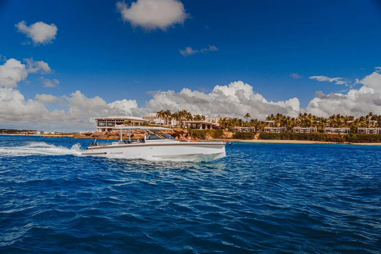 Emotion Boat Club's white powerboat cruising beside the St Martin coastline